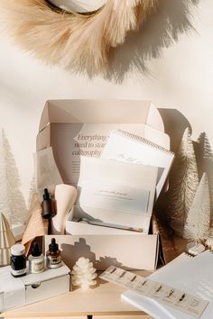 the contents of a beauty box sitting on a table next to a feather and other items