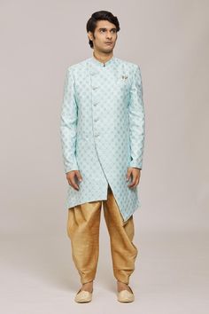 Firozi asymmetric sherwani with woven floral patterns. Comes with dhoti pant.
Components: 2
Pattern: Woven
Type Of Work: Floral
Neckline: Mandarin Collar
Sleeve Type: Full
Fabric: Sherwani: Mercury Jacquard Churidar: Silk Dupion
Color: Blue
Other Details: 
Embellished buttons
Closure:
Sherwani: Front button
Dhoti pant: Drawstring
Note: Pocket square worn by the model is not for sale
Occasion: Sangeet,Mehendi and Puja - Aza Fashions Sherwani With Dhoti, Dhoti Pants For Men, Blue Sherwani, Embellished Buttons, Dhoti Pants, Churidar, Floral Patterns, Mandarin Collar, Pocket Square