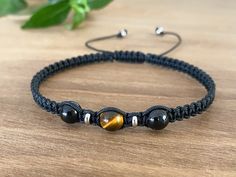 a black cord bracelet with tiger's eye beads