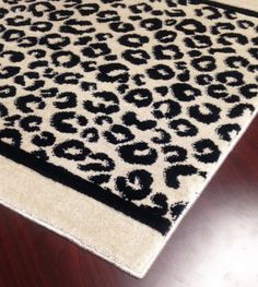 a black and white rug on top of a wooden floor