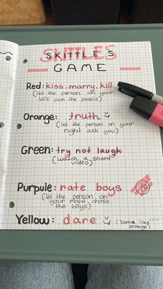 a notebook with writing on it that says skittles game next to a pen