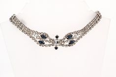 Add a touch of vintage glamour to your special day with this stunning Vintage Rhinestone Choker Necklace. Featuring a beautiful combination of Sapphire Blue and Crystal rhinestones, this piece is the perfect something blue for your wedding ensemble. The exquisite Marquise stones add an elegant and eye-catching detail, making this necklace a timeless and classic accessory. Elevate your bridal look with this sparkling choker that will surely make you shine on your big day. This choker measures 16".  The clasp is a hook making it adjustable. Elegant Blue Rhinestone Necklace For Formal Occasions, Elegant Blue Rhinestone Necklace For Wedding, Blue Rhinestone Necklaces For Evening, Elegant Blue Rhinestone Necklace Gift, Blue Rhinestone Necklace For Evening, Elegant Blue Rhinestone Necklace With Sparkling Stones, Blue Crystal Rhinestone Necklace For Wedding, Vintage Rhinestone Choker Jewelry, Vintage Rhinestone Crystal Choker Necklace