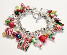 a close up of a bracelet on a white surface with christmas decorations and candy items