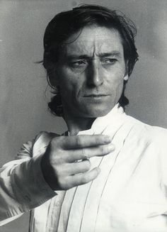 a black and white photo of a man with his hand on his shoulder