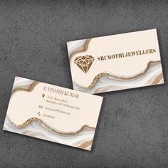 two business cards designed to look like marble with gold accents and a diamond on the front