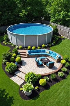 an above ground swimming pool surrounded by lush green grass and landscaping area with seating around it