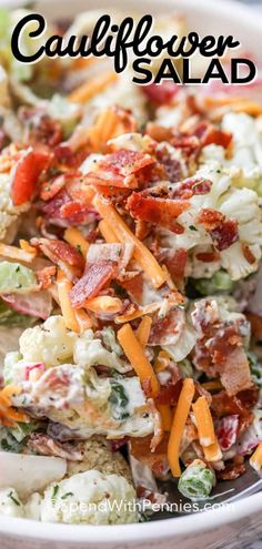 a salad with bacon, cheese and lettuce in a white bowl on a wooden table