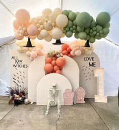 an arch made out of balloons and other decorations in front of a white tent with the words all my witches on it