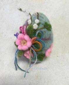 a close up of a flower on top of a cloth bag with thread and beads