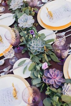 the table is set with flowers and plates