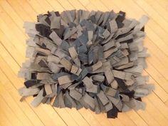 a pile of gray paper sitting on top of a wooden floor