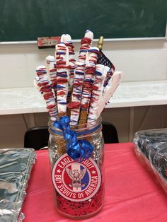 a mason jar filled with patriotic candy sticks