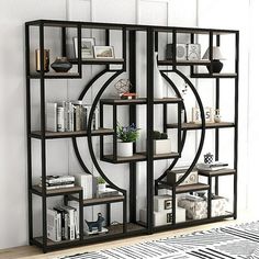 a book shelf with books on it in front of a white wall and zebra rug