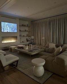 a living room filled with furniture and a flat screen tv mounted to the wall over a fireplace