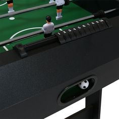 a foo - ball table with three players on it