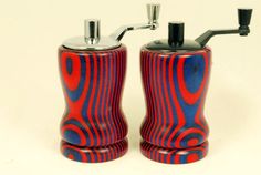 two red and blue salt and pepper shakers on a white surface with black handles