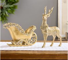 two gold reindeer figurines sitting on top of a table