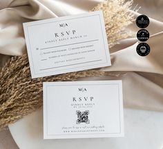 two wedding cards sitting on top of a white plate next to some dried grass and burlock