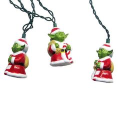 three christmas lights hanging from a string on a white background, one with an ornament in the shape of a santa clause