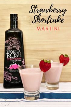 strawberry shortcake martini in front of a bottle and two glasses with strawberries on the side