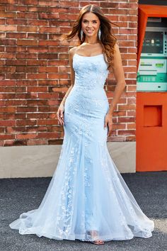 a beautiful woman in a blue dress posing for the camera with her hand on her hip