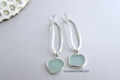 Find a gift she'll cherish. Timeless jewelry for every occasion. Our sterling silver and sea glass dangle earrings feature a long, slender modern design. OOAK pieces of surf tumbled sea glass are first chosen to coordinate, then carefully wrapped in fine silver bezel wire with an eye-catching polish. Each lengthy oval of sterling wire is shaped and hammered by artisan Susan Volger. There is a lot of movement in these earrings and they are very comfortable to wear. They dangle from a pair of ster Silver Sea Glass Earrings For Gift, Elegant Silver Sea Glass Earrings, Handmade Silver Sea Glass Earrings, Handmade Silver Earrings With Sea Glass, Elegant Sea Glass Dangle Earrings, Silver Sea Glass Dangle Earrings, Seaglass Jewellery, Bezel Wire, Beachy Jewelry