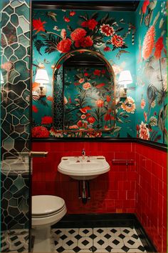 a bathroom with red and green wallpaper has a white toilet, sink and mirror