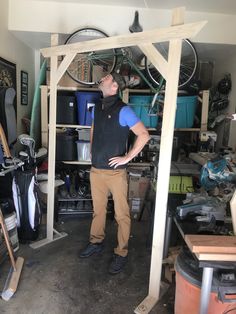 a man standing in a garage with his hands on his hips and looking up at the ceiling