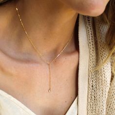 "Our lariat necklace is perfect minimalist jewelry. This dainty necklace is perfect with your favorite tee or your little black dress. A tiny cubic zircon drop adorns a 14kt gold filled chain.  D E T A I L S *Tiny cubic zircon drop - gold over sterling silver  *2 inch drop  *Dainty link chain *100% 14kt gold dainty link chain  LENGTH *The standard length is normally 18\". *Model is wearing a 16\" in Photos. HOW TO PERSONALIZE *Select your choices from the drop down menu to create your custom design. ∙ EXTRA LOVE ∙ Handcrafted just for you in sunny Arizona by a team of talented women. All of our jewelry comes gift packaged! We are happy to leave a note if this is a special gift, just let us know in the message box at checkout. PRODUCTION ∙ TIMES All items are made to order. Please check the Dainty Rose Gold Lariat Necklace, Everyday Dangle Charm Necklace With Clavicle Chain, Everyday Clavicle Chain Charm Necklaces With Dangle, Dainty Lariat Drop Necklace With Adjustable Length, Sterling Silver Clavicle Chain Lariat Necklace For Everyday, Everyday Sterling Silver Lariat Necklace With Clavicle Chain, Sterling Silver Lariat Necklace For Everyday, Simple Adjustable Jewelry As A Gift, Minimalist 14k Gold Filled Dangle Charm Necklace