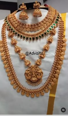 a gold necklace and earring set on display