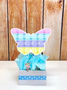 a box filled with lots of candy and some paper on top of a white table