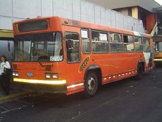 an orange bus parked in front of a building