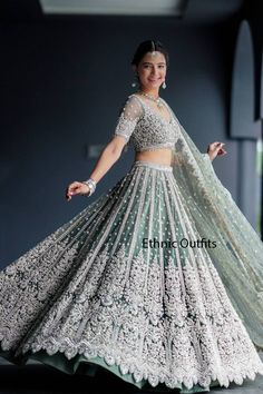 a woman in a white and green lehenga