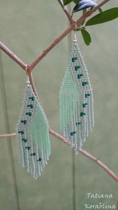 beaded earrings hanging from a tree branch