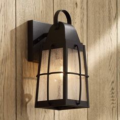 an outdoor light mounted on the side of a wooden wall