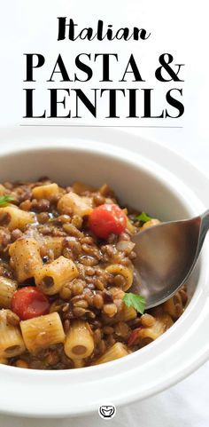 a white bowl filled with pasta and lentils on top of a table next to a spoon