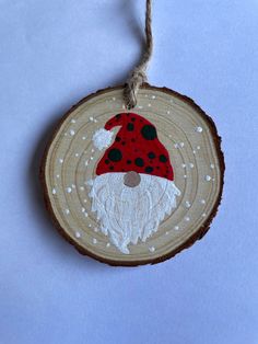 a wooden ornament with a red and white gnome on it's face