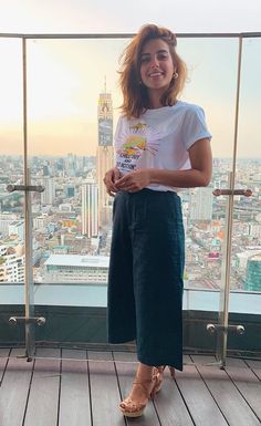 a woman standing on top of a tall building