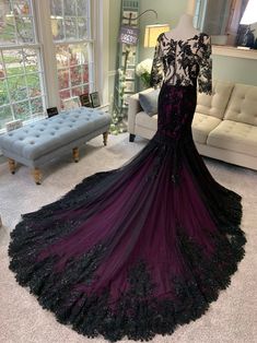 a black and purple dress is on display in a room with couches, pillows and windows