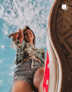 a woman standing on top of a pair of shoes with her feet up in the air