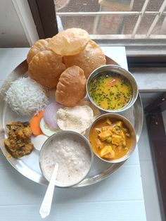 a white plate topped with different foods on top of a window sill next to a window