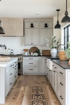 a kitchen with white cabinets and black counter tops, an area rug on the floor