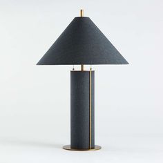 a black lamp with a gold base and a blue shade on the top, sitting on a white surface