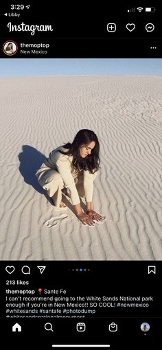 a woman kneeling down in the sand with her hands on her knees and feet crossed