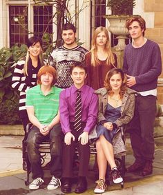 a group of people sitting on top of a bench in front of a building next to each other