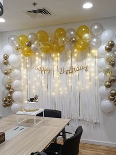 a birthday party with balloons and streamers on the wall