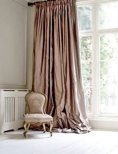 a chair sitting in front of a window next to a radiac heater