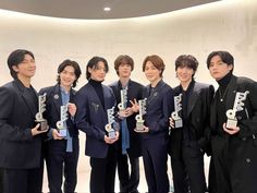 group of young men in suits holding up trophies