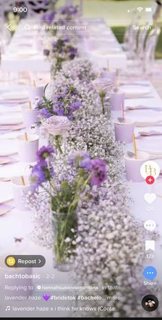 the table is set with purple flowers and place settings for each person to sit at