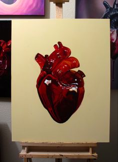 a painting of a red heart on a white canvas in front of some other paintings